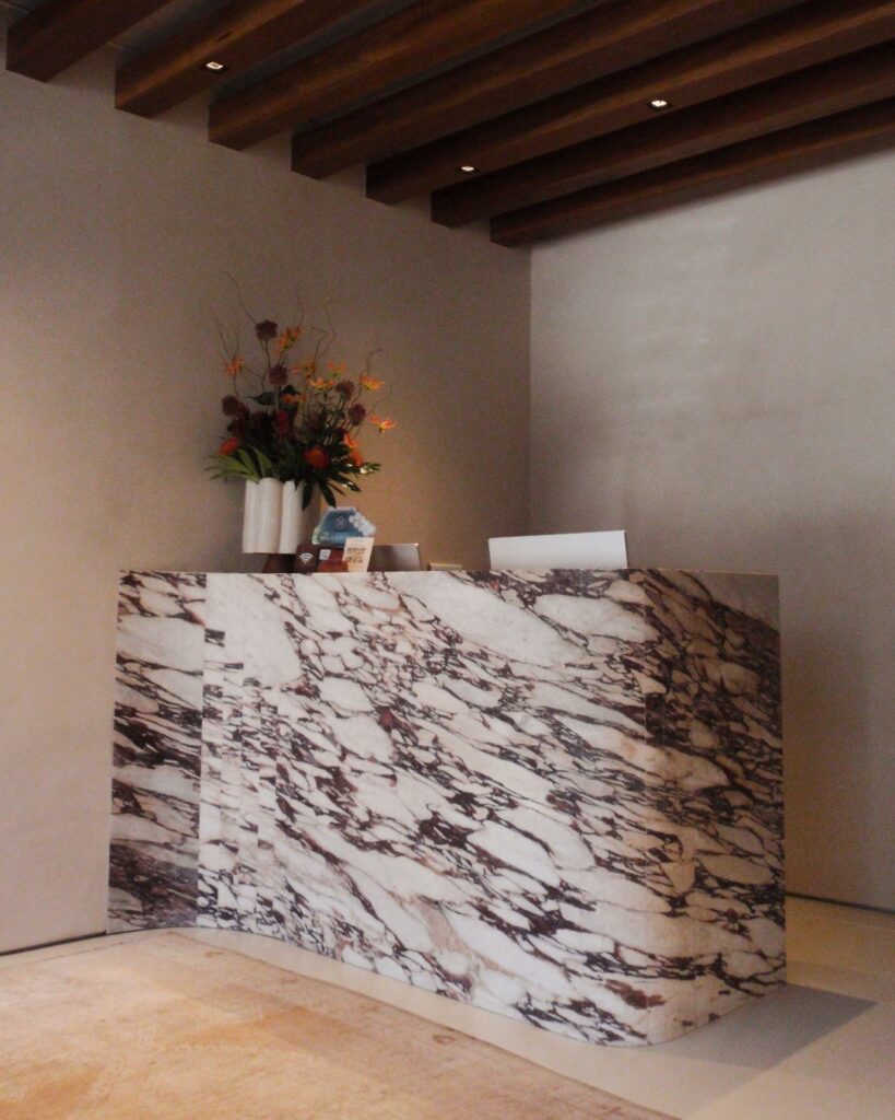 Marble reception desk with floral arrangement at Elinea San Francisco